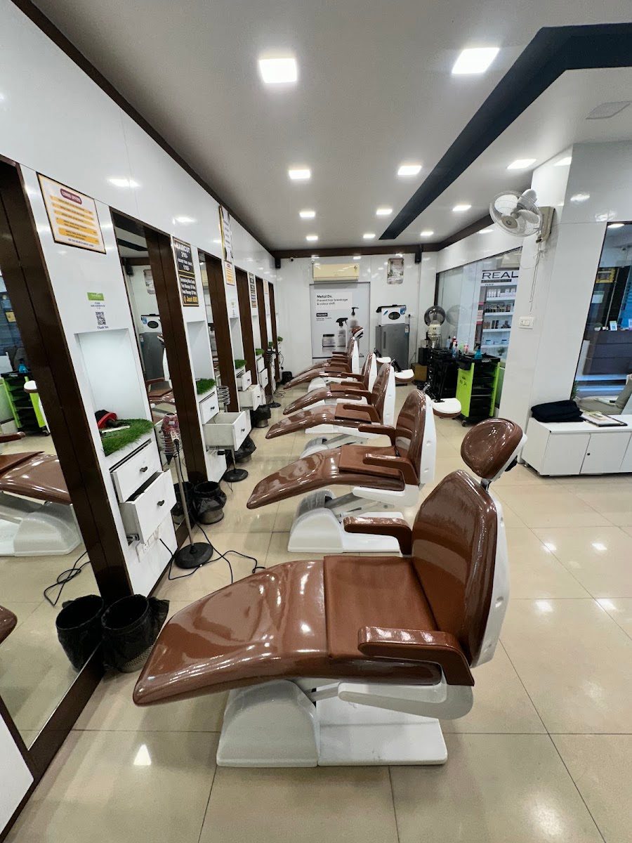 Row of leather styling chairs and mirrors down the length of Dreams Men's Salon.
