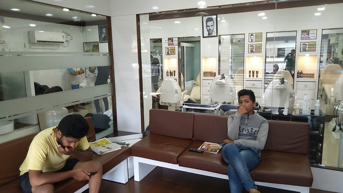 Customers waiting on the leather bench in the Dreams Men's Salon lounge.