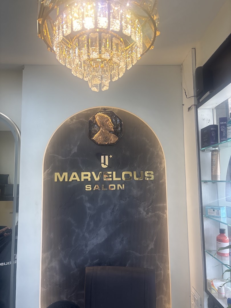 The gold Marvelous Salon logotype glowing on the black-marble arch wall