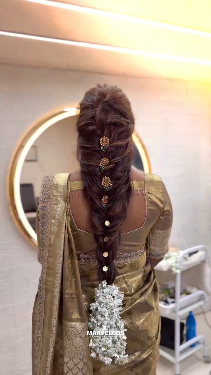 An elaborate bridal braid styled with flowers, from the salon's Instagram
