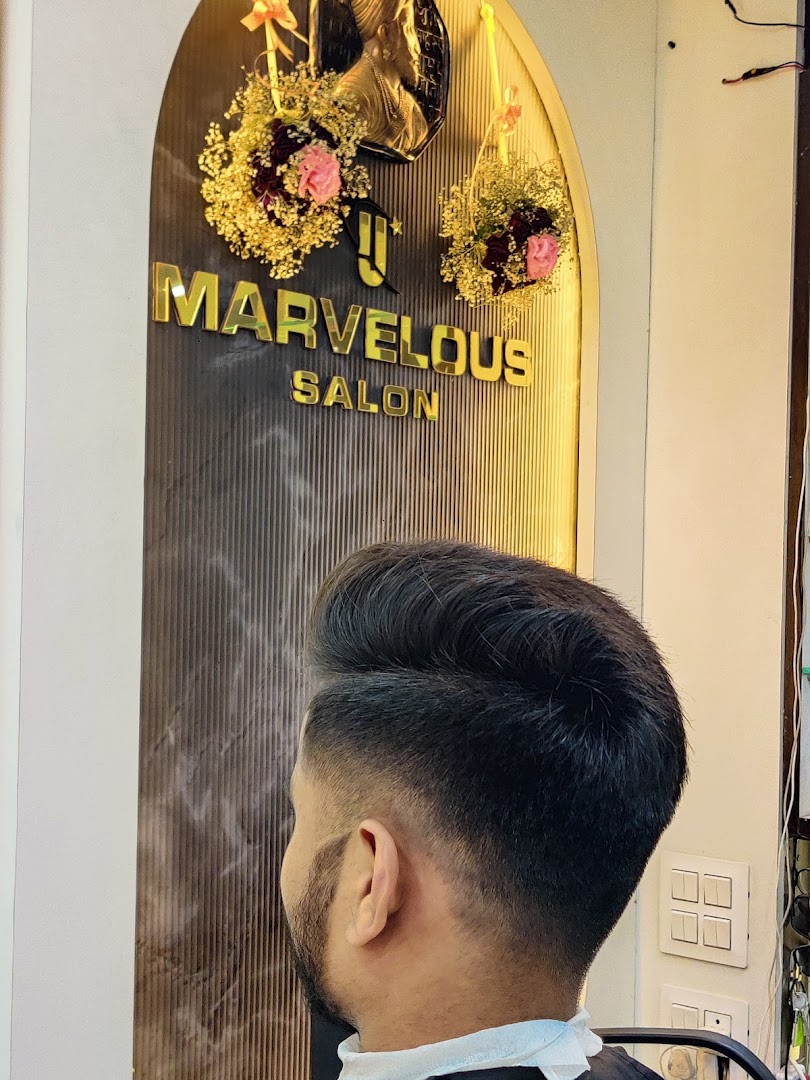 A stylist mid-haircut beneath the gold Marvelous logo