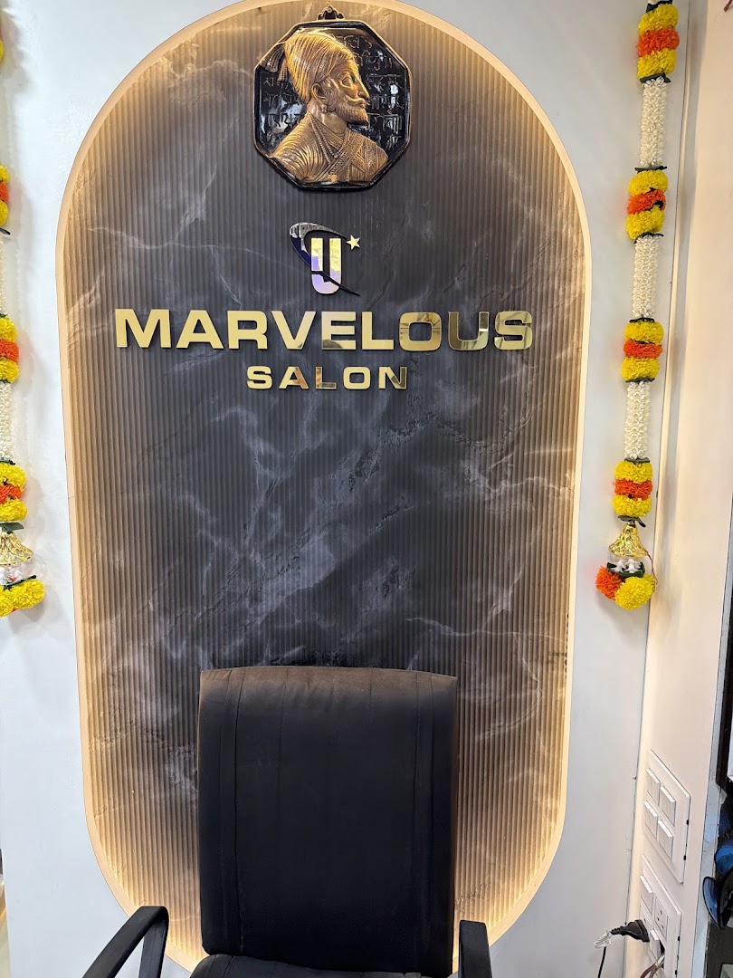 The gold Marvelous logotype on the salon's black-marble reception arch, framed in fluted wood