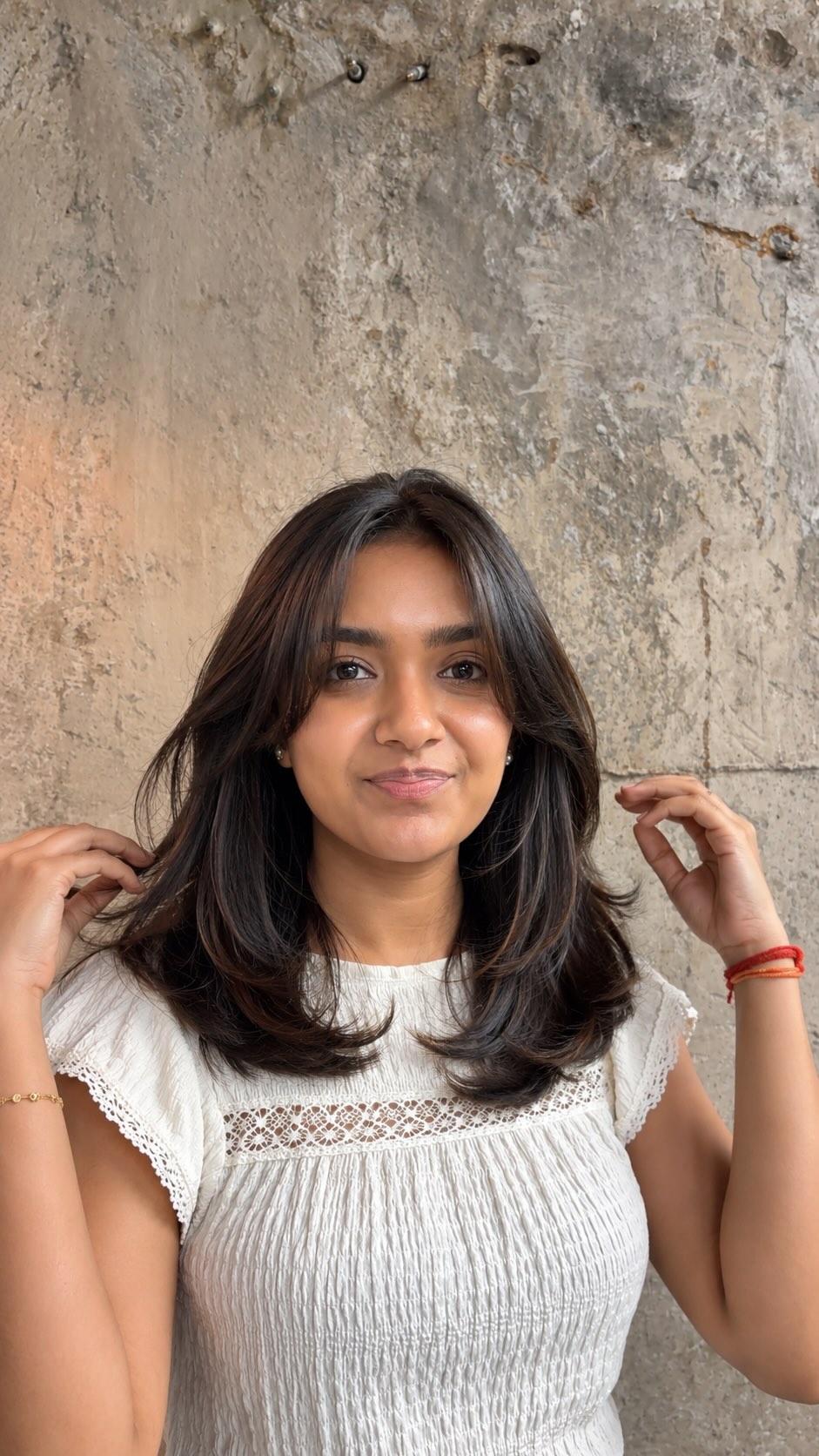 Layered haircut with soft curtain bangs by Salon Muah