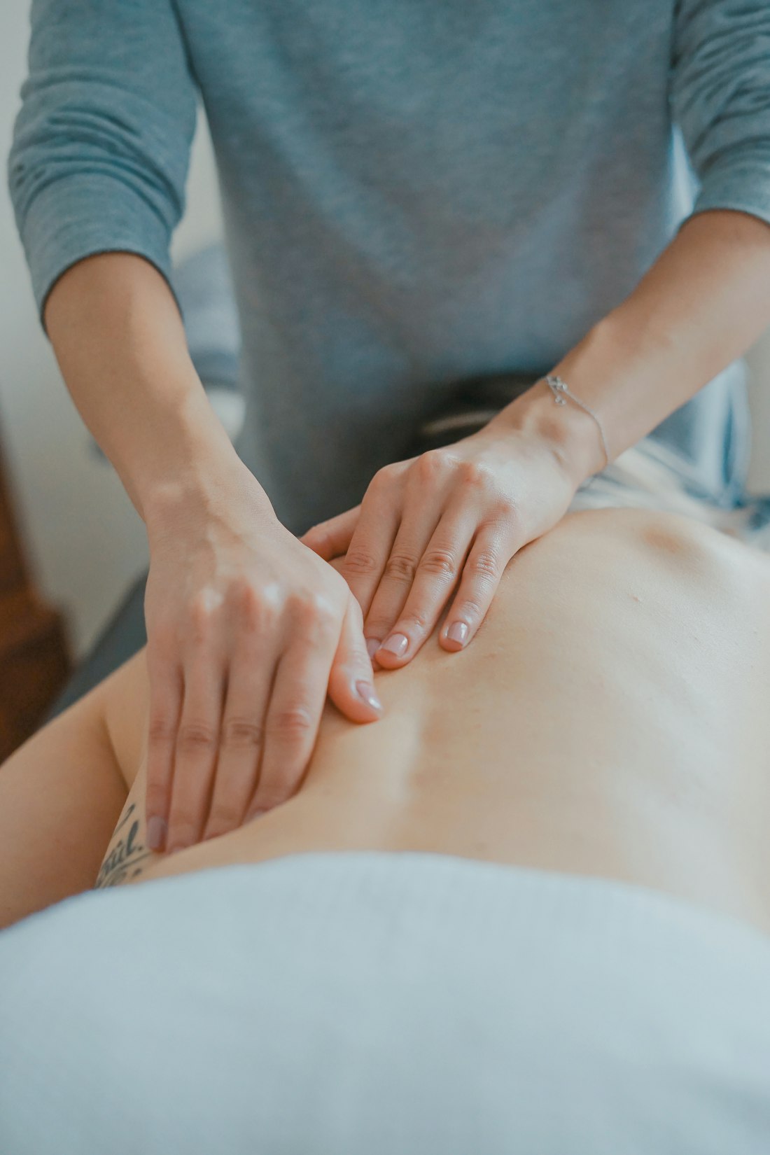 Deep tissue back massage — a therapist's hands working steadily along the lower back